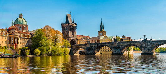 A view along the eastern shore of the Vltava river and the Charles Bridge in Prague in springtime