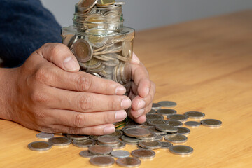 A young man guarding his savings in a glass jar, symbolizing financial protection and caution.