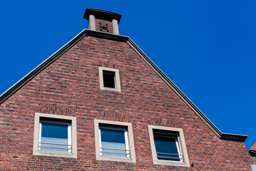 Red brick building under clear blue sky with windows and chimney