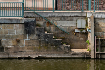 Stairway leading to calm water by city waterfront