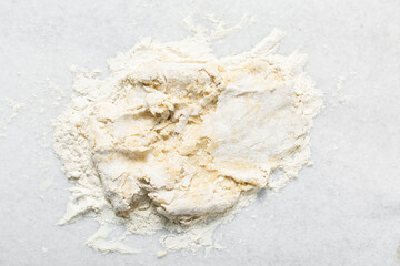 Overhead view of doughnut dough being kneaded on a white countertop, top view of doughnut dough on...