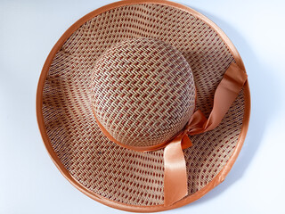 Peach and red summer wide brimmed woven or straw woman hat with bow isolated on white background....