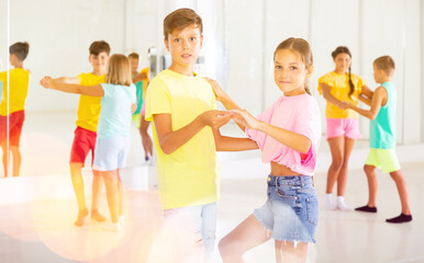 Naklejka premium Portrait of active children enjoying of partner dance in class