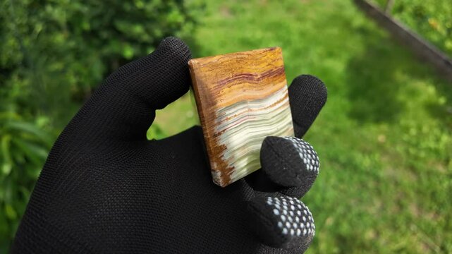 Middle-aged woman with green orgone stone pyramid. triangular stone pyramid. pyramid on the palm. stone symbol. magic item. Man showing a green orgone pyramid, close up