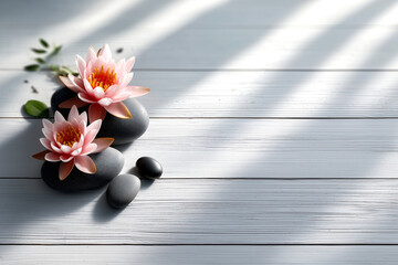 Pink lotus flowers on black spa stones over white wooden background with shadows. Concept of relaxation, natural beauty, and wellness advertising with copy space