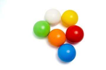 Top view of six colorful plastic balls arranged in a circle on a clean white background