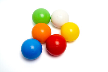 Top view of six colorful plastic balls arranged in a circle on a clean white background