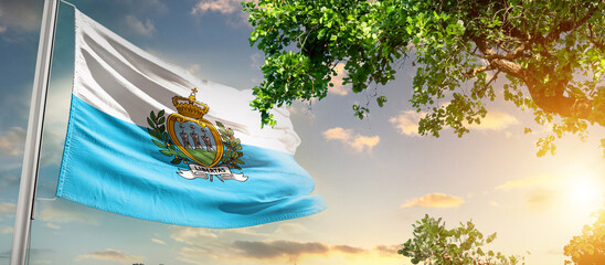 San Marino national flag waving in the sky behind the tree. The flag blow in beautiful sunlight....