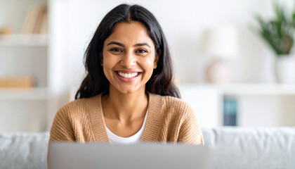 Happy young woman using laptop sitting at desk writing notes while watching webinar, studying online, looking at pc screen learning web classes or having virtual call meeting remote working from home.
