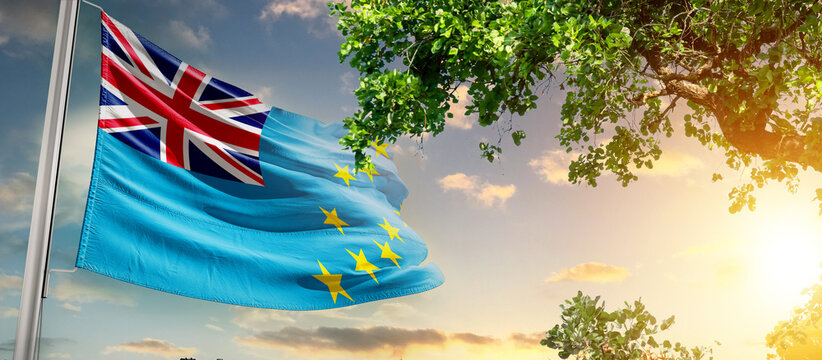 Tuvalu national flag waving in the sky behind the tree. The flag blow in beautiful sunlight. Tuvalu national flag for independence day.