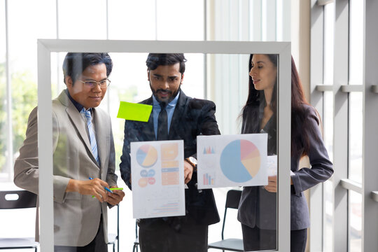 Brainstorm Mindmapping : Diverse Professionals Brainstorming on Glass Wall with Sticky Notes. Asian indian man. Shows Graphs, Infographics, AI, Big Data, Mindmapping. Glass Board and Marker