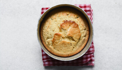 Overhead view of homemade cake in a cake pan, top view of fresh cake on countertop