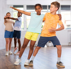 Active young multinational children enjoying of partner dance in in dance studio