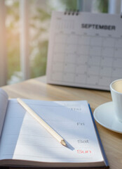 Calendar book for Planner to plan reminder daily appointment timetable, appointment, organization, and meeting agenda of job on wooden desk, work from home-vertical image.