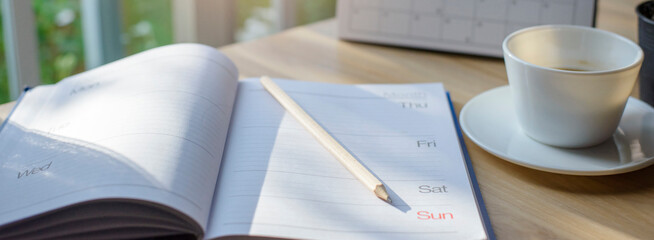 Calendar book for Planner to plan reminder daily appointment timetable, appointment, organization, and meeting agenda of job on wooden desk, work from home-banner image.