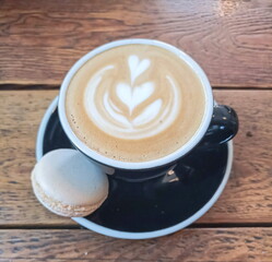 Cappuccino cup and macaroon biscuits on a plate