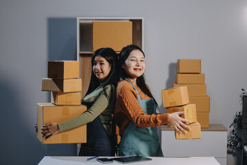 Startup SME small business entrepreneur of freelance Asian woman wearing apron using laptop and box...