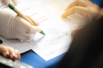 physical therapist hand with glove pointing pen explaining BMI results patient consultation