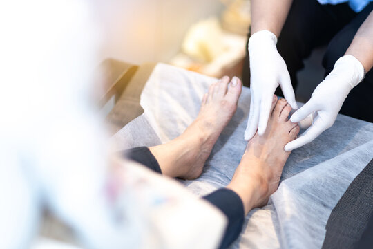 Nurse examining elderly patient feet healthcare podiatry medical checkup close up
