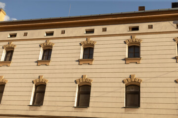 The beautifully detailed facade of a historic building prominently showcases its intricately designed windows and various architectural elements that highlight its rich heritage