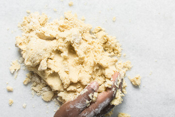 overhead view of vanilla sugar cookie dough being kneaded on countertop, top view of plain vanilla cookie dough being mixed, process of making sugar cookies