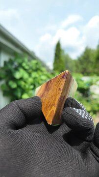 Middle-aged woman with green orgone stone pyramid. triangular stone pyramid. pyramid on the palm. stone symbol. magic item. Man showing a green orgone pyramid, close up