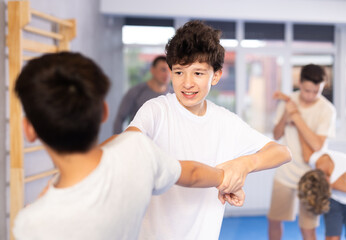 Obraz premium Sedulous underage practitioner of self-defense courses applying attack methods on his opponent