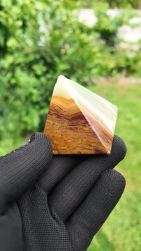 Middle-aged woman with green orgone stone pyramid. triangular stone pyramid. pyramid on the palm. stone symbol. magic item. Man showing a green orgone pyramid, close up