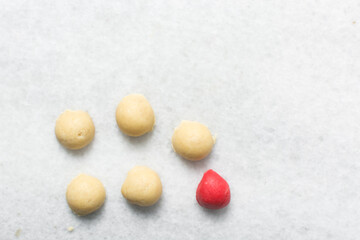 Overhead view of Vanilla and strawberry pink sugar cookie dough on a parchment lined baking sheet,...