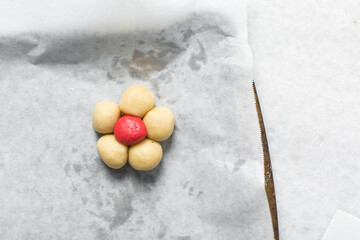 Overhead view of Vanilla and strawberry pink sugar cookie dough on a parchment lined baking sheet,...