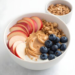 Photo of a creamy peanut butter yogurt parfait, adorned with juicy apple slices, plump blueberries, and crunchy granola, sits in a white bowl
