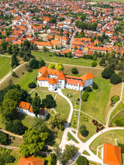 Aerial view of the historical Varaždin Castle surrounded by green parkland and urban development...