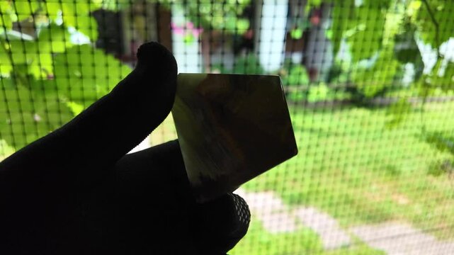 Middle-aged woman with green orgone stone pyramid. triangular stone pyramid. pyramid on the palm. stone symbol. magic item. Man showing a green orgone pyramid, close up