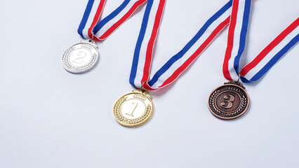 Gold silver and bronze demonstration trophy medals with ribbon for school university or national or olympic sport even organization competition. Isolated on white background. Award and victory concept