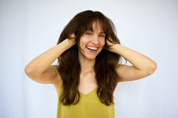 Beautiful happy playful brunette with the big smile holding her beautiful long thick hair on the...