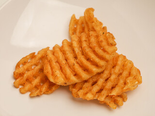 Waffle fries piled on white plate