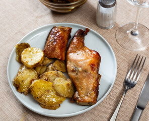 Baked juicy and crispy rabbit pieces served with spicy roasted potatoes