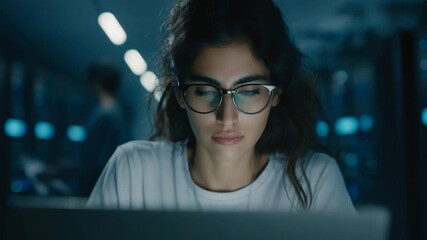 Focused young woman works on a laptop in a server room late at night for data analysis - Powered by Adobe