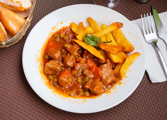 Delicious beef stew served on plate with potatoes and stewed vegetables