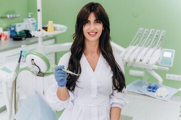 Portrait of a young female dentist in uniform at a modern dental clinic, smiling confidently