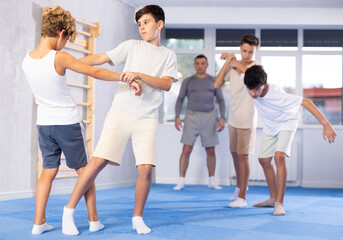 Sedulous underage practitioner of self-defense courses applying attack methods on his opponent