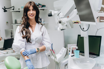 Portrait of a young female dentist in uniform at a modern dental clinic, smiling confidently.