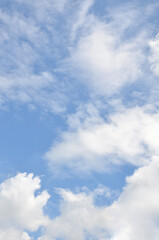 Vertical bright blue sky with  fluffy clouds trame background. Nature, atmosphere, sky landscape in sunny weather.	