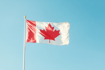 A Canadian flag with a red maple leaf on it is flying in the sky