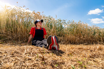 Young woman relaxing by cereal field enjoying peaceful countryside