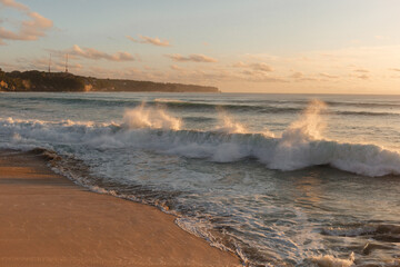 Raging ocean waves in the setting sun. Foamy waves wash the coast of the island of Bali. Vacation on a tropical island