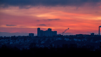 Silhouette of constructing buildings against amazing sunset red sky.