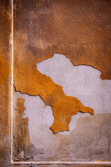 Rustic cracked wall with peeling orange plaster and rough texture, perfect urban grunge background