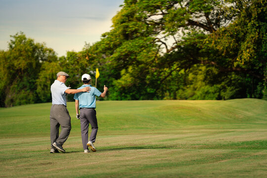 Good shot buddy. Shot of two happy men playing a game of golf. Golf, friends and sport with men on course playing - Powered by Adobe