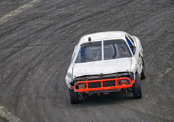 2025-06-14 A WHITE RACE CAR WITH A ORANGE BUMBER ENTERING A CORNER AT THE RACE TRACK AT THE EVERGREEN STATE FAIRGROUNDS IN MONROE WASHINGTON